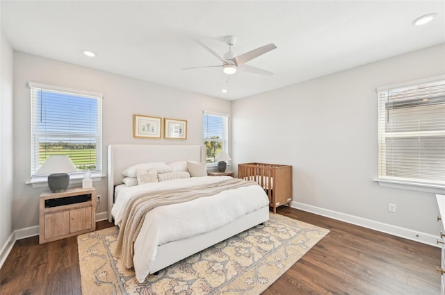 bedroom featuring baseboards, multiple windows, and wood finished floors