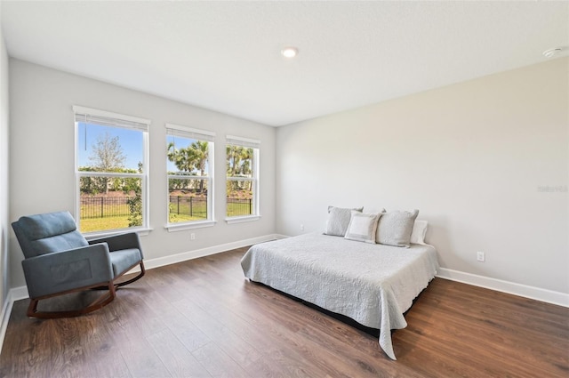 bedroom with baseboards and dark wood-style flooring