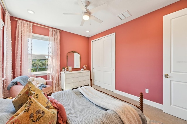 carpeted bedroom with baseboards, visible vents, a closet, and ceiling fan