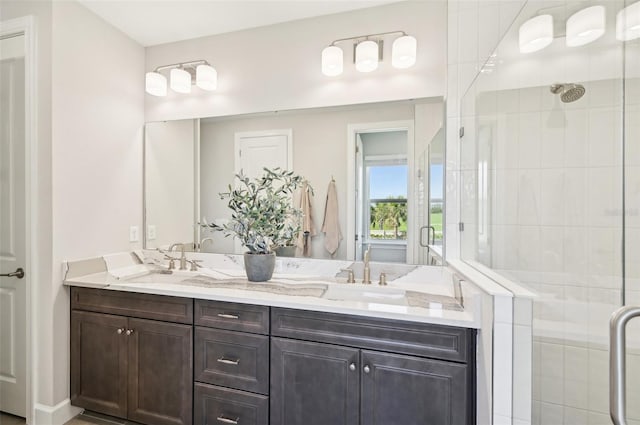 bathroom featuring a shower stall, double vanity, and a sink