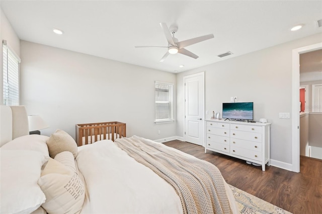 bedroom with visible vents, multiple windows, dark wood-type flooring, and baseboards