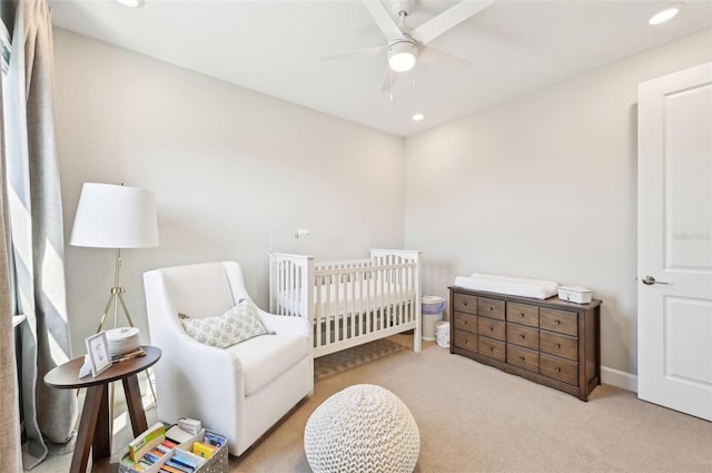 carpeted bedroom featuring recessed lighting, baseboards, a crib, and ceiling fan