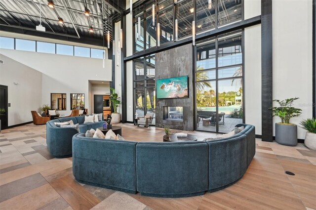 living room with a high ceiling, baseboards, and a premium fireplace