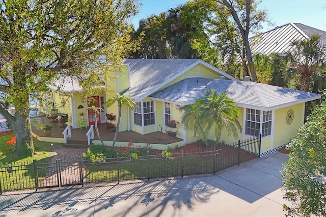 view of front facade featuring a fenced front yard and roof with shingles