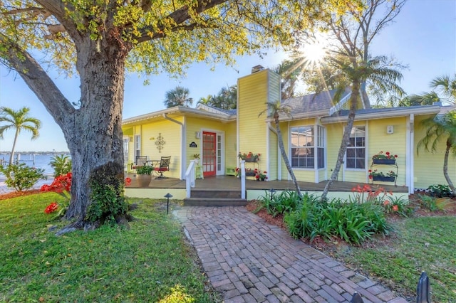 single story home with a front lawn and a chimney