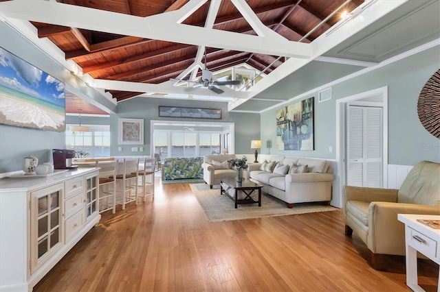 living area with visible vents, light wood-style flooring, a ceiling fan, lofted ceiling with beams, and wooden ceiling