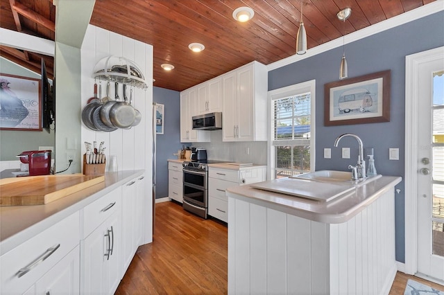 kitchen with wood ceiling, appliances with stainless steel finishes, wood finished floors, white cabinetry, and a sink