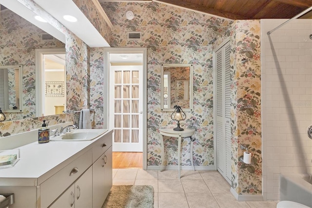 bathroom featuring tile patterned floors, visible vents, baseboards, and wallpapered walls