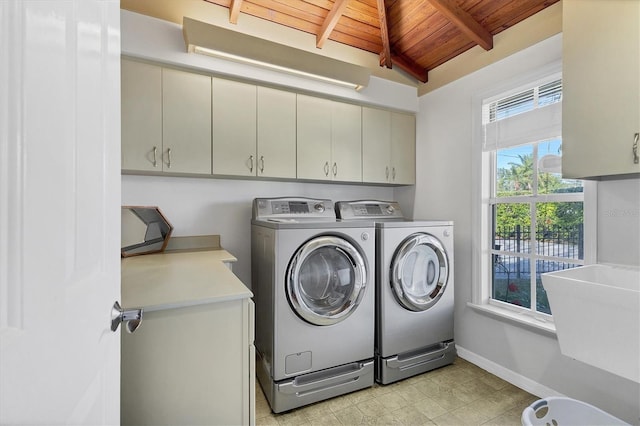 washroom featuring cabinet space, wooden ceiling, baseboards, and separate washer and dryer