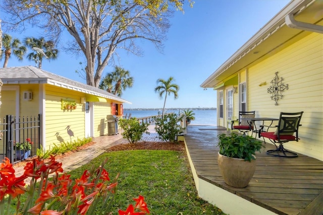 view of yard with a deck with water view and fence