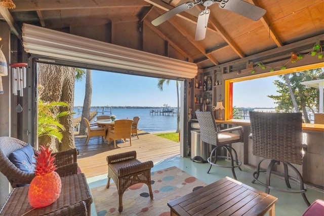 view of patio with outdoor dining area, ceiling fan, and a deck with water view