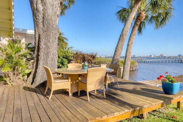 view of dock featuring outdoor dining area and a water view