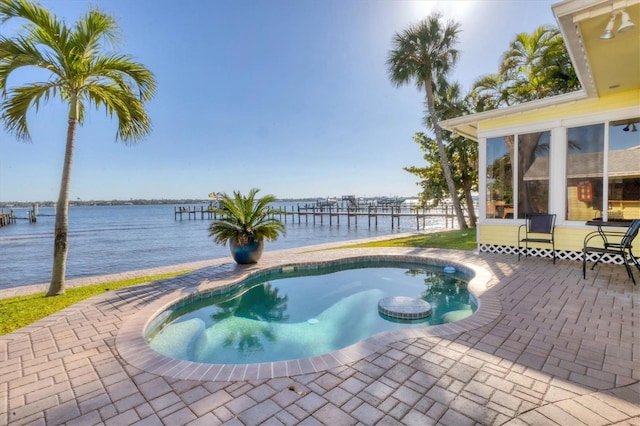 outdoor pool featuring a patio area and a water view