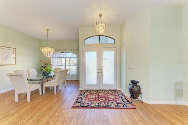 foyer entrance with an inviting chandelier, wood finished floors, baseboards, and french doors