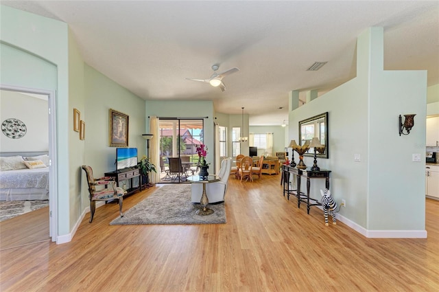 living area with light wood-style flooring, baseboards, and visible vents