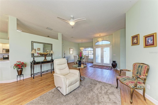 living area featuring visible vents, french doors, a textured ceiling, and wood finished floors