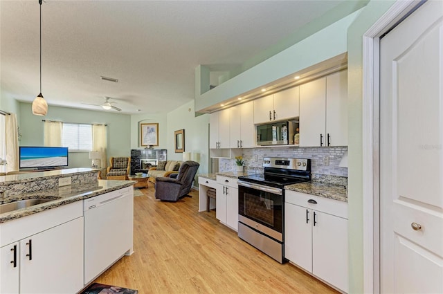 kitchen with tasteful backsplash, visible vents, decorative light fixtures, light wood-style flooring, and appliances with stainless steel finishes