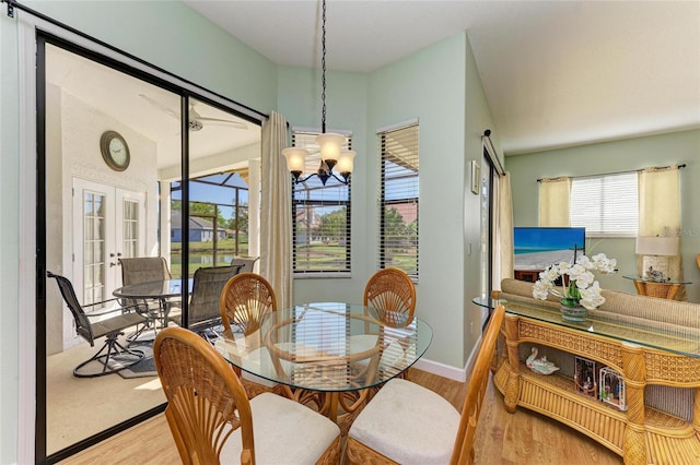 dining area featuring french doors, baseboards, a notable chandelier, and light wood finished floors