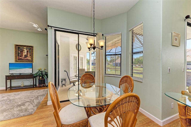 dining room featuring a wealth of natural light, baseboards, and light wood-style floors