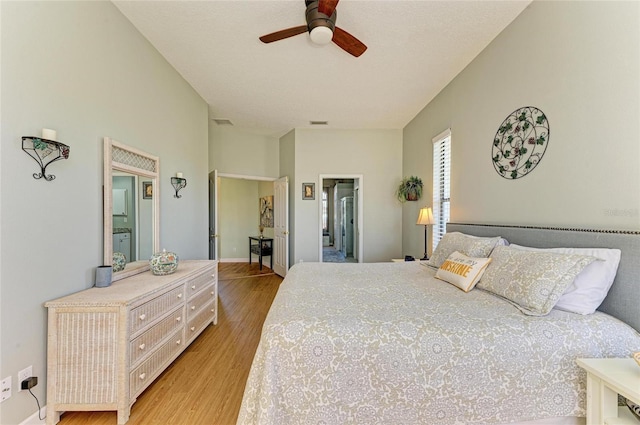 bedroom with visible vents, a ceiling fan, light wood-type flooring, and baseboards