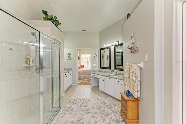 ensuite bathroom featuring vanity, ensuite bath, visible vents, and a stall shower