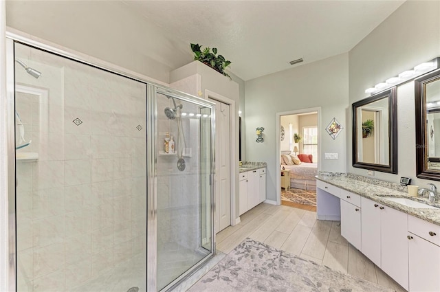 full bathroom featuring vanity, ensuite bath, visible vents, and a shower stall