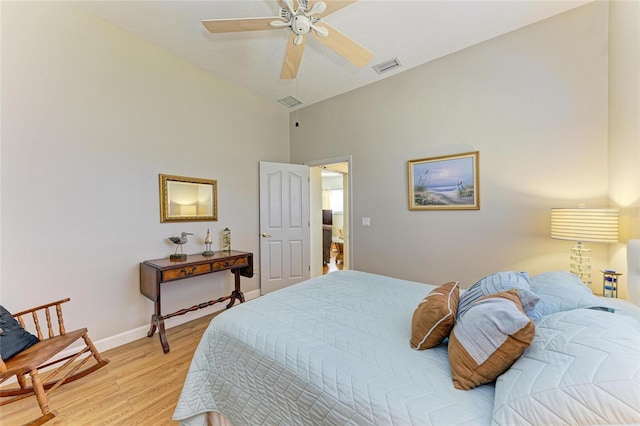 bedroom with a ceiling fan, visible vents, baseboards, light wood-style flooring, and vaulted ceiling