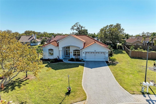 mediterranean / spanish home with a front lawn, a tile roof, a garage, and fence