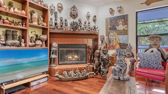 interior space with a fireplace, wood finished floors, and a textured ceiling