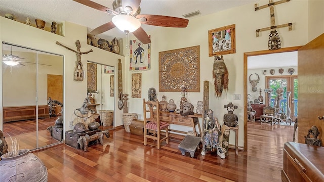 interior space with visible vents, ceiling fan, and wood finished floors