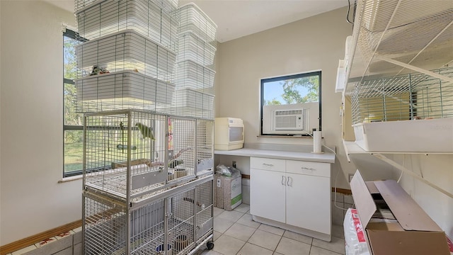 interior space featuring cooling unit, baseboards, light tile patterned flooring, and a towering ceiling