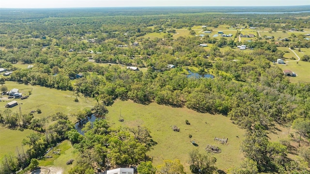 drone / aerial view with a forest view and a water view