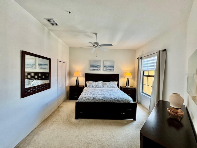 bedroom with visible vents, light carpet, and a ceiling fan