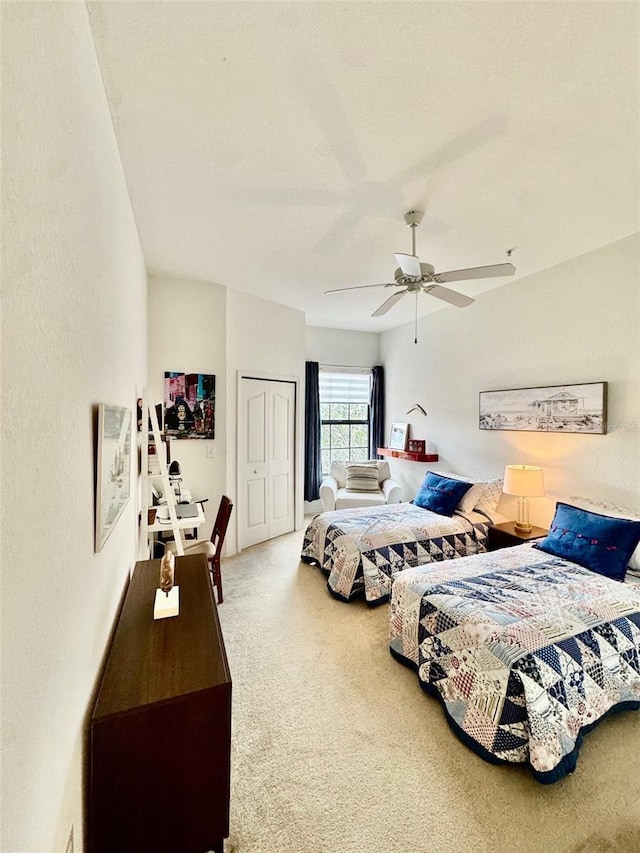 bedroom featuring a textured wall, a closet, carpet floors, and ceiling fan