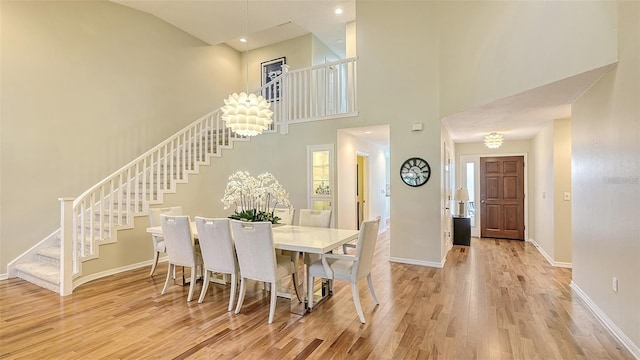 dining room with stairway, baseboards, and light wood finished floors