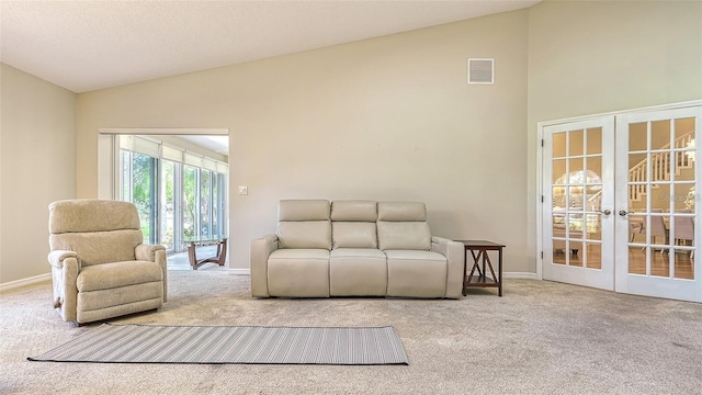 living room featuring visible vents, carpet floors, baseboards, lofted ceiling, and french doors