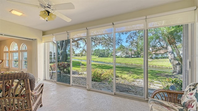 sunroom / solarium featuring plenty of natural light, a water view, and ceiling fan