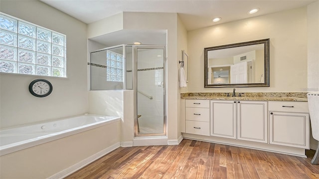 full bathroom with vanity, a shower stall, a bath, and wood finished floors