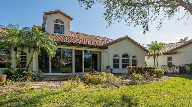 rear view of property with stucco siding and a tiled roof