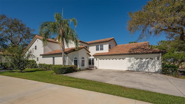 mediterranean / spanish-style home featuring stucco siding, concrete driveway, a tile roof, and a garage