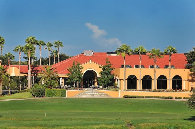 view of front facade featuring a front yard and a tile roof