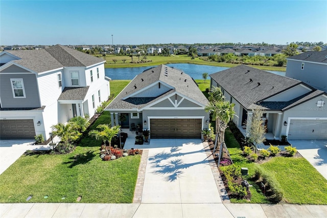 view of front of home featuring driveway, a garage, a water view, and a residential view