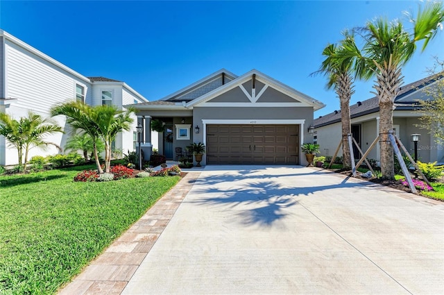 view of front of house featuring stucco siding, a front lawn, concrete driveway, and a garage