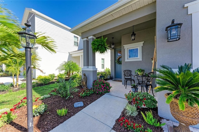 entrance to property with a porch and stucco siding