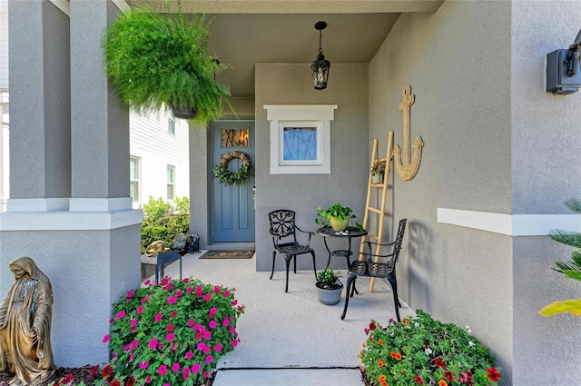 property entrance with stucco siding and a porch