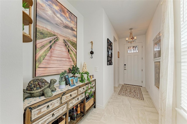 entryway with baseboards, marble finish floor, and a chandelier