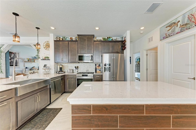 kitchen with a sink, stainless steel appliances, visible vents, and decorative backsplash