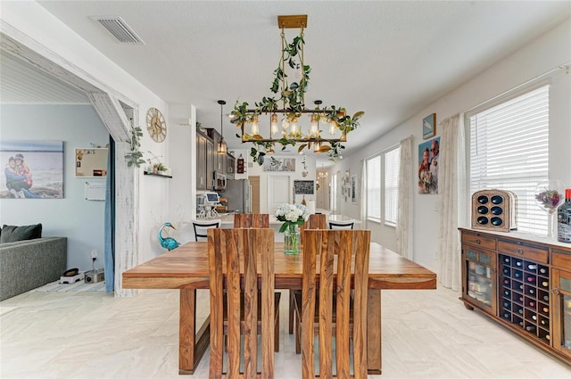 dining area with visible vents and an inviting chandelier