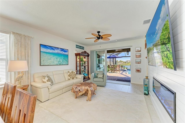 living room with visible vents, a textured ceiling, and a ceiling fan