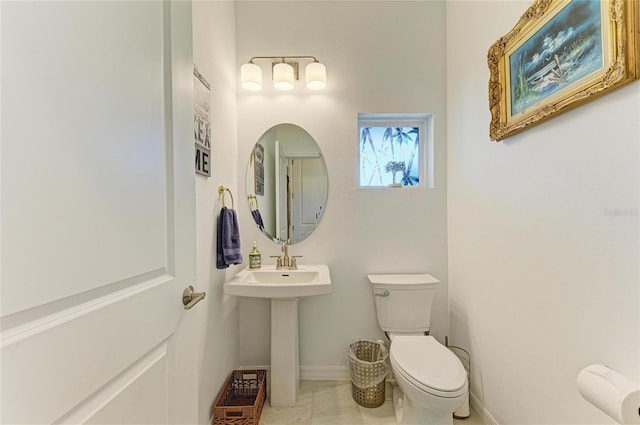 half bath with baseboards and toilet